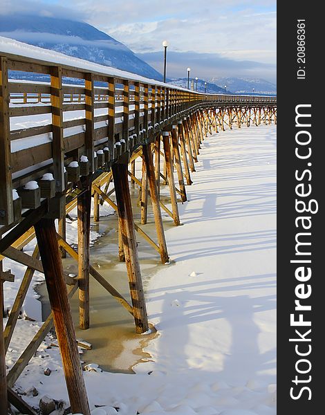 Wooden pier with snow at frozen lake in Salmon Arm