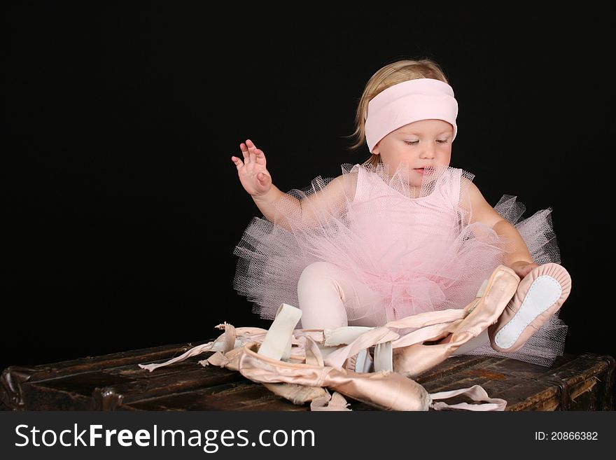 Blond toddler wearing a tutu holding Ballet shoes. Blond toddler wearing a tutu holding Ballet shoes