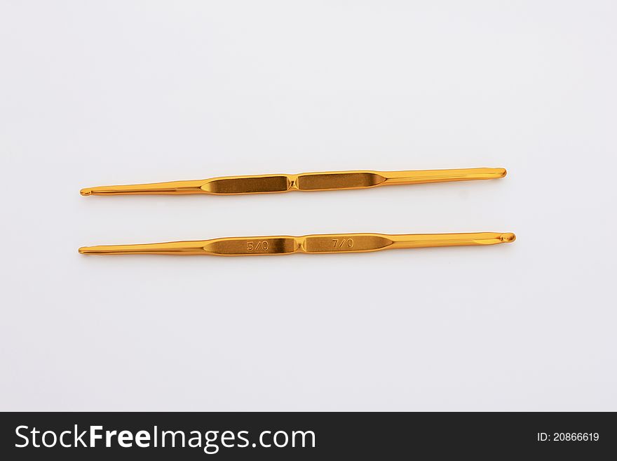 Number 5 and 7 of golden crochet hooks on a white background for knit dolls, bags, etc.