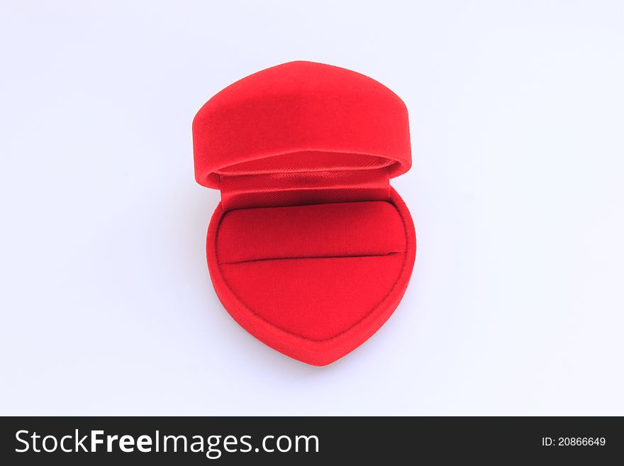 A heart-shaped ring box covered with red velvet on white background