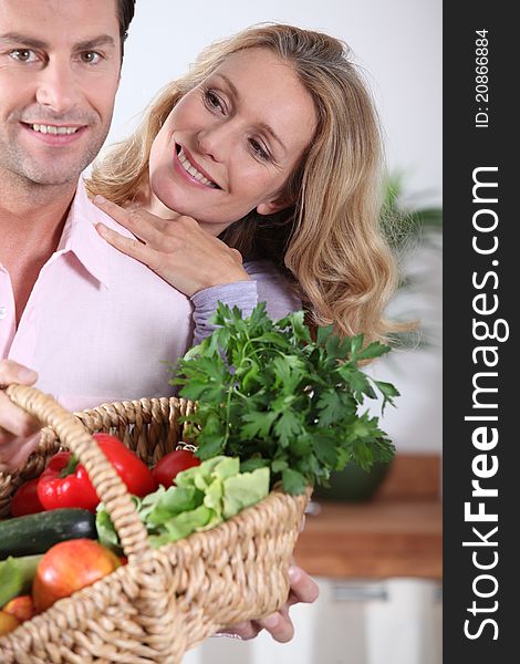 Couple with vegetable basket in the kitchen