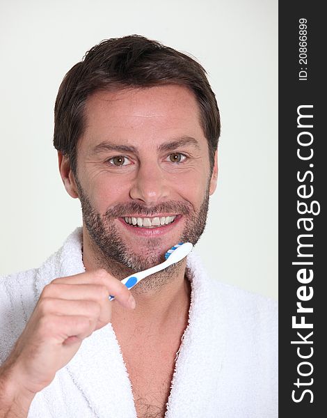 Good looking mature man brushing his teeth in the morning. Good looking mature man brushing his teeth in the morning