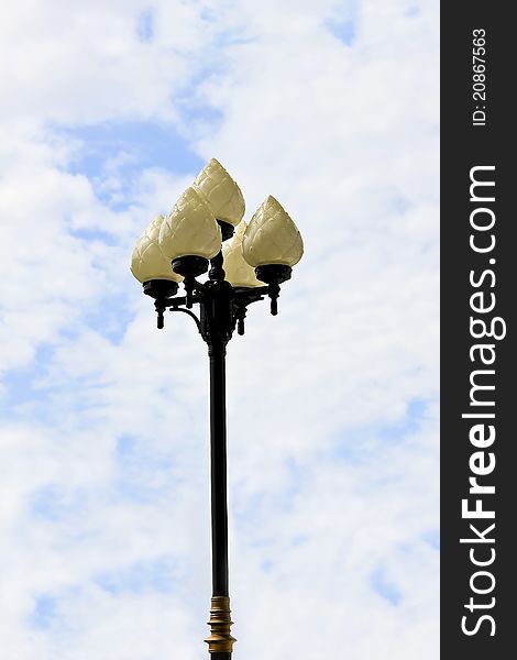 Classic lamp post with ivory lotus lanterns on a blue sky background. Classic lamp post with ivory lotus lanterns on a blue sky background.