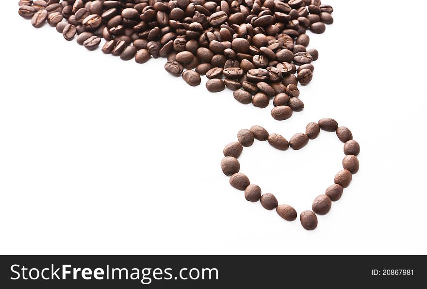 Brown roasted coffee beans in heart shape isolated on white background