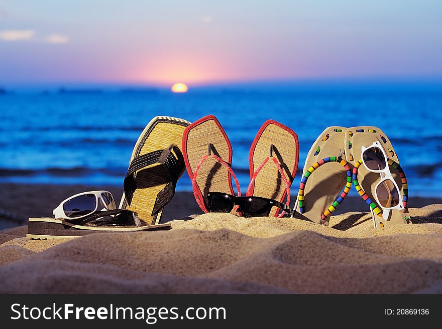 Beach sandals and glasses on the beach in evening. Beach sandals and glasses on the beach in evening