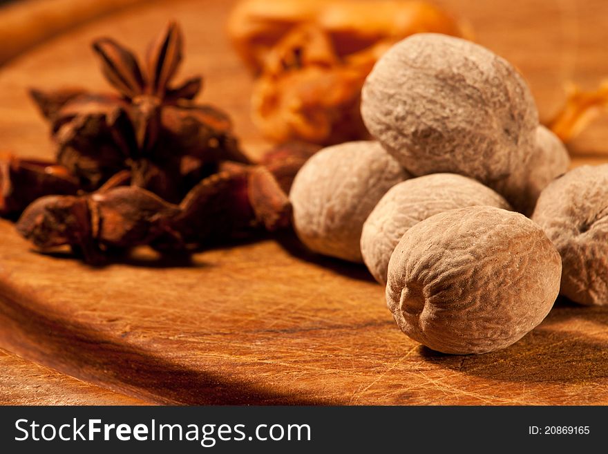 Nutmeg and star anise spices on a wooden cutting board. Nutmeg and star anise spices on a wooden cutting board