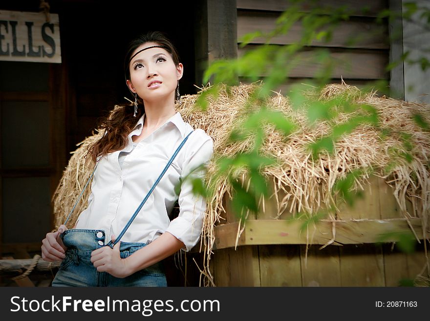 Portrait of a confident young cowgirl standing beside thatch