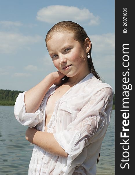 The girl the teenager in a white shirt after bathing in lake. The girl the teenager in a white shirt after bathing in lake