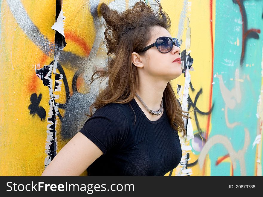 Punk girl standing near graffiti