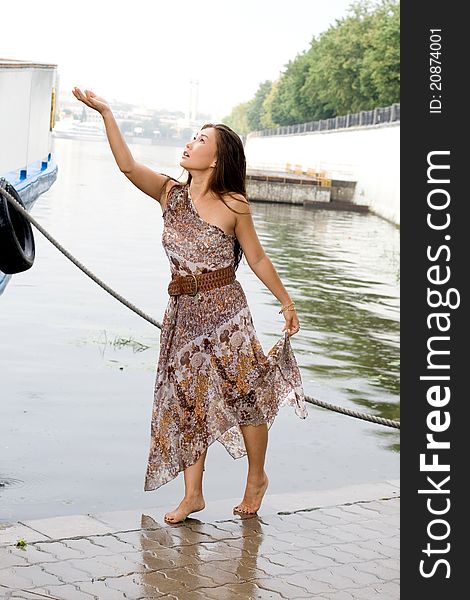 Beautiful girl walking near river in summer