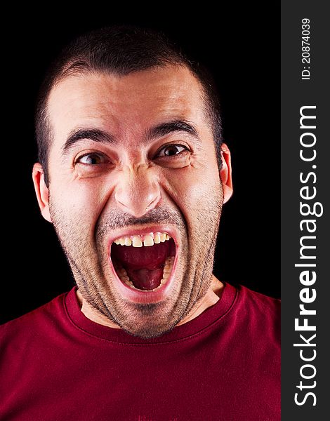 Close detail view of a screaming young male man isolated on a black background. Close detail view of a screaming young male man isolated on a black background.