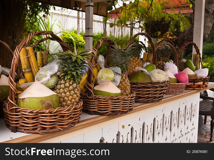 Fruits in basket on shelves included bananas sugarcanes coconuts and pineapples tilted right. Fruits in basket on shelves included bananas sugarcanes coconuts and pineapples tilted right