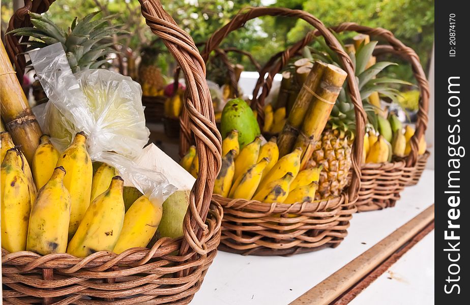 Fruits in basket on shelves included bananas sugarcanes and pineapples tilted out. Fruits in basket on shelves included bananas sugarcanes and pineapples tilted out