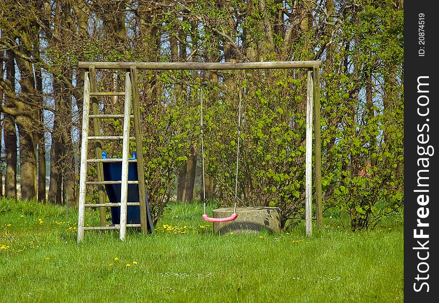 Red garden swing in a small outdoors garden