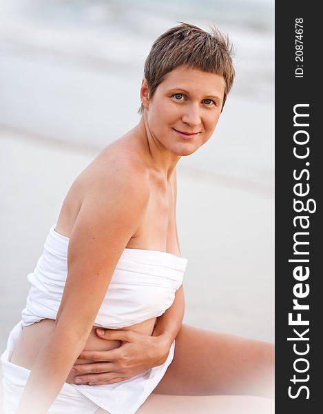 Woman is holding pregnant belly on the ocean. Woman is holding pregnant belly on the ocean