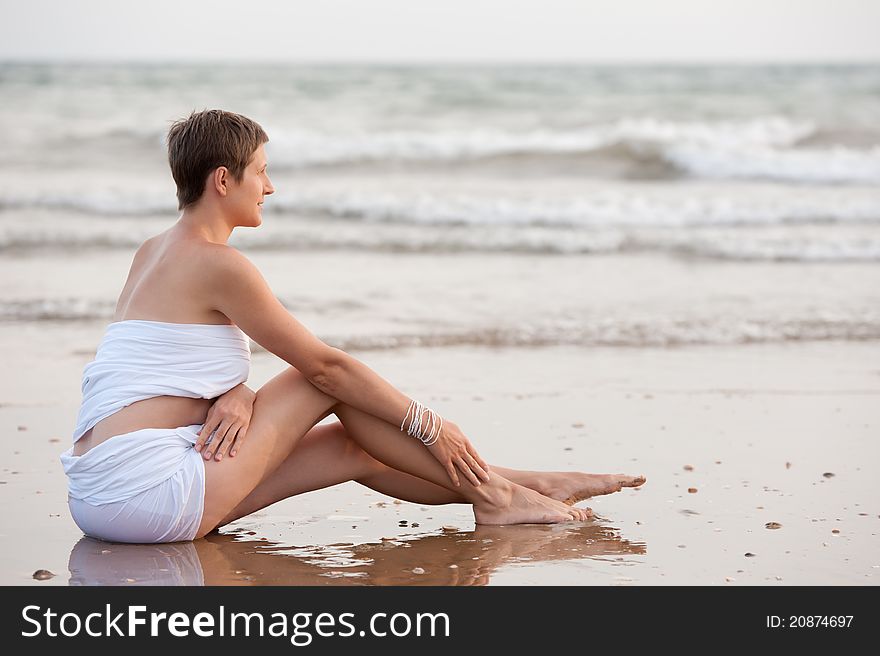 Young woman sitting on beach. Young woman sitting on beach