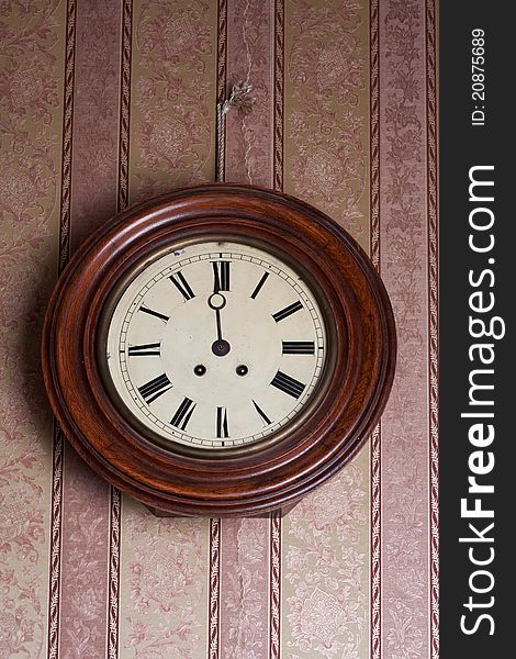 Retro wall clock on a background of vintage wallpaper