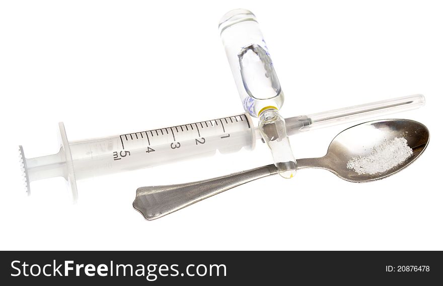 Spoon, syringe, vial on a white