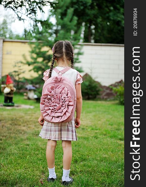 Young school girl with pink backpack poses outdoors. Young school girl with pink backpack poses outdoors