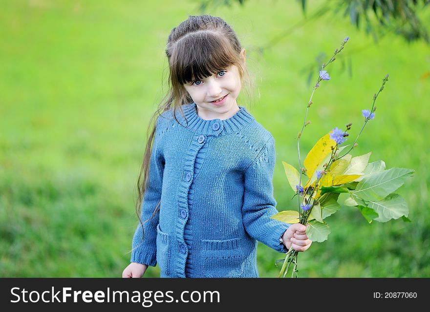 Adorable Child Girl Poses Outdoors With Leaves