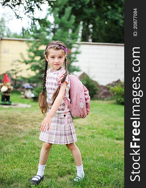 Young school girl with pink backpack poses outdoors. Young school girl with pink backpack poses outdoors