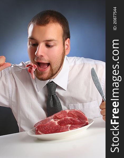 Eccentric guy eating red meat. Eccentric guy eating red meat