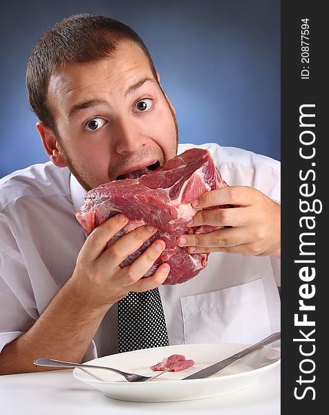 Eccentric guy eating red meat. Eccentric guy eating red meat