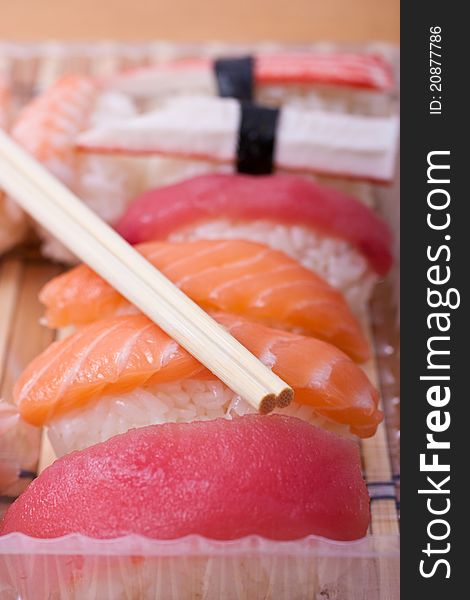Take away sushi set with chopsticks. Selective focus. Take away sushi set with chopsticks. Selective focus.