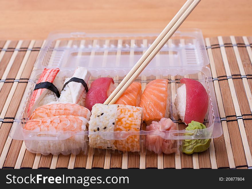 Take away sushi set with chopsticks. Selective focus. Take away sushi set with chopsticks. Selective focus.