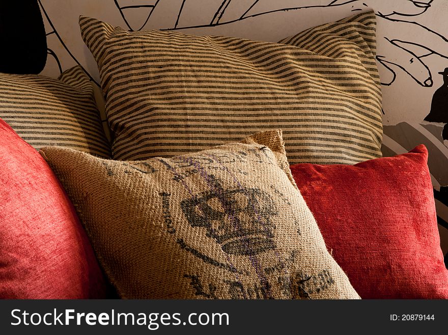 Red and sackcloth pillows closeup in grunge style decorated arrangement. Red and sackcloth pillows closeup in grunge style decorated arrangement