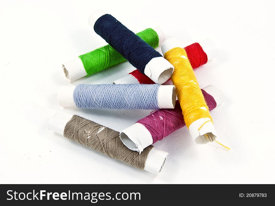 A mixture of colorful spools of thread put messily.