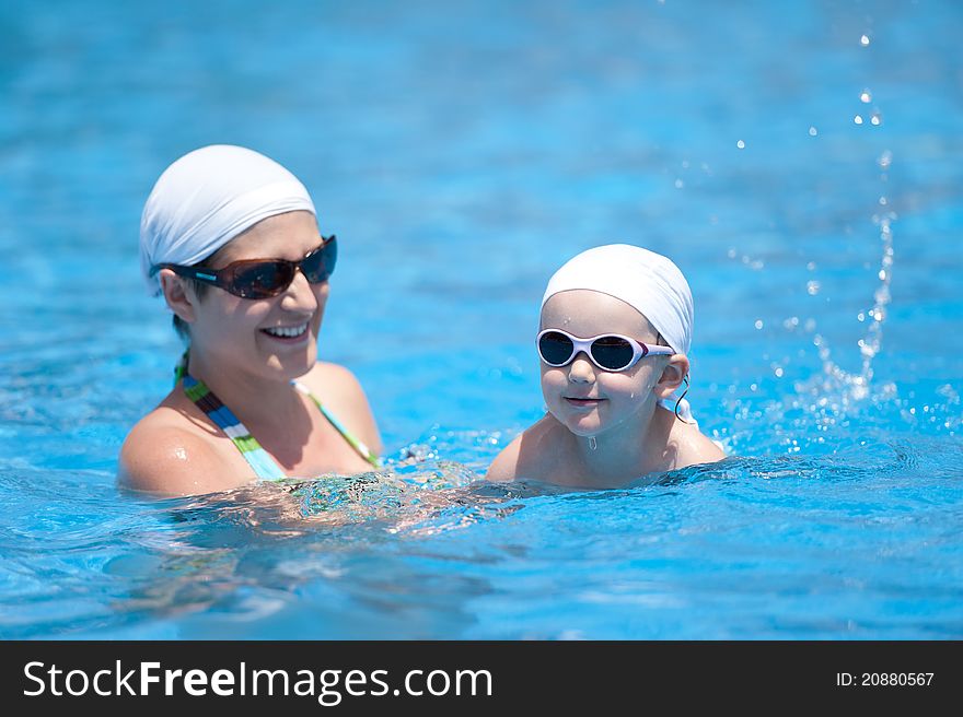 Mother and baby are swimming in swimming pool