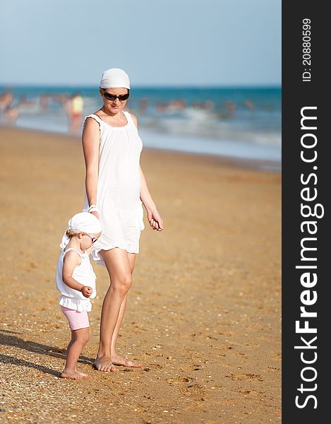 Mother With Baby Are Walking On Beach