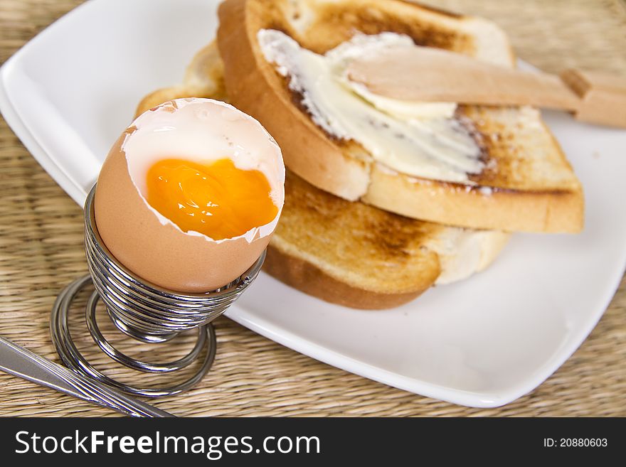 Soft boiled egg with crispy toasts on the plate. Soft boiled egg with crispy toasts on the plate