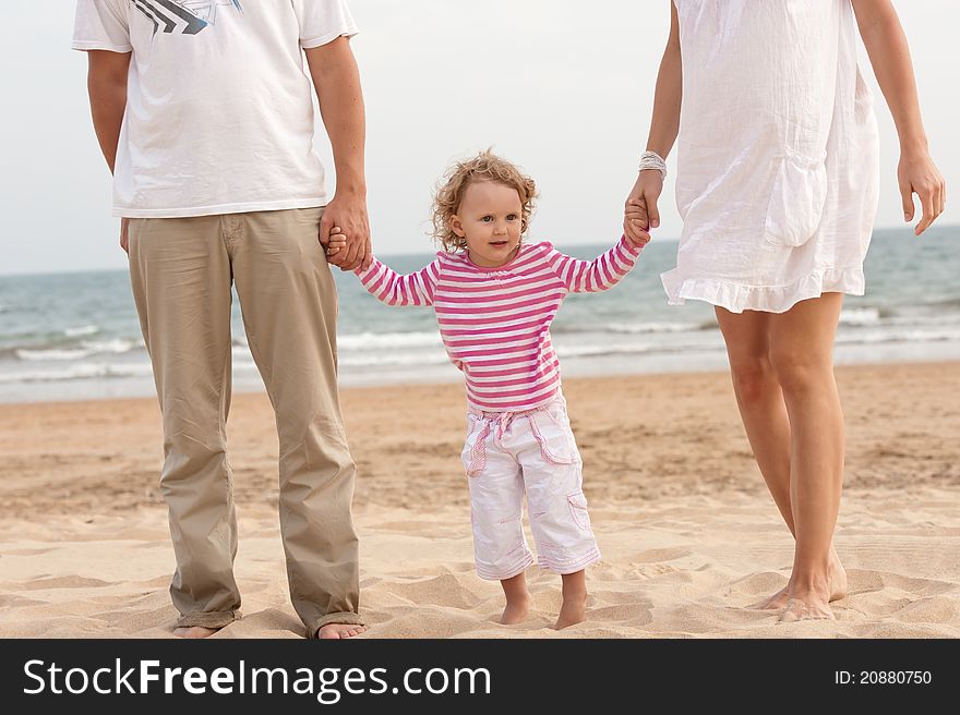 Family Parents And Baby Walking On The Beach
