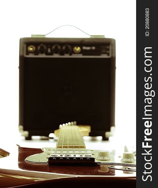 Electric guitar and amplifier isolated on the white background with retro look, focus point is on guitar. Electric guitar and amplifier isolated on the white background with retro look, focus point is on guitar