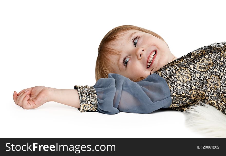 Little girl lying on the floor in the studio on a white background