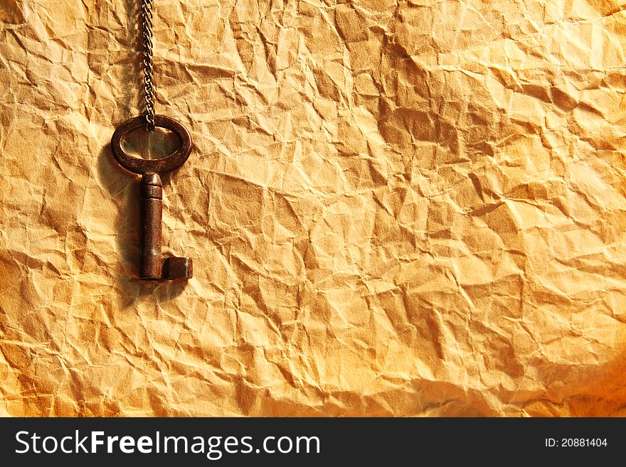 Blank sheet of crumpled paper and old key on chain. Blank sheet of crumpled paper and old key on chain
