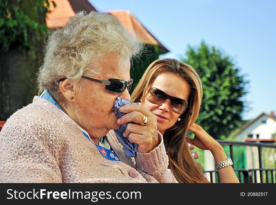 Portrait of grandmother and granddaughter taken in the exterior.