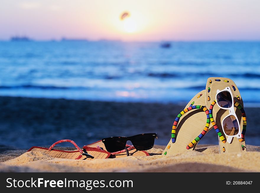 Beach sandals and glasses on the beach in evening. Beach sandals and glasses on the beach in evening