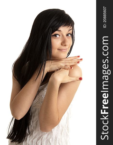 Beautiful brunette girl wearing a white dress putting her hands to the face  and standing on white background