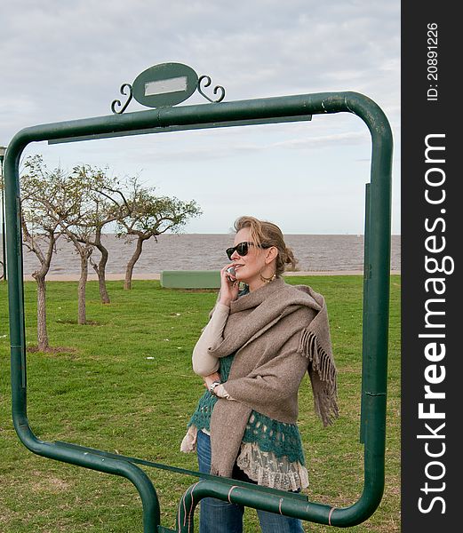 Woman taking on the celular phone, taken framed in a urban park. Woman taking on the celular phone, taken framed in a urban park.