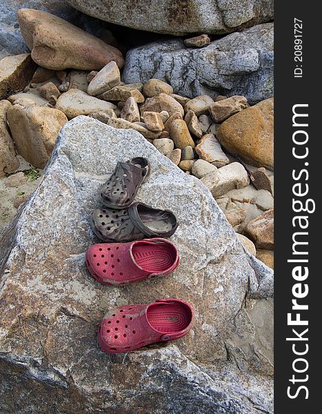 Beach shoes on a rock means it's summer at last. Beach shoes on a rock means it's summer at last