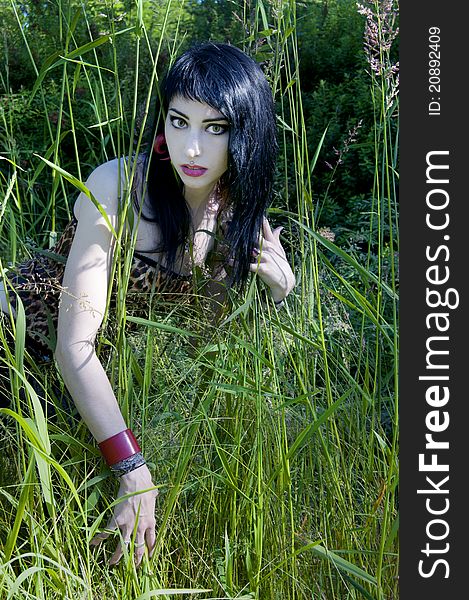 Gorgeous brunette model sitting in the green grass. Gorgeous brunette model sitting in the green grass