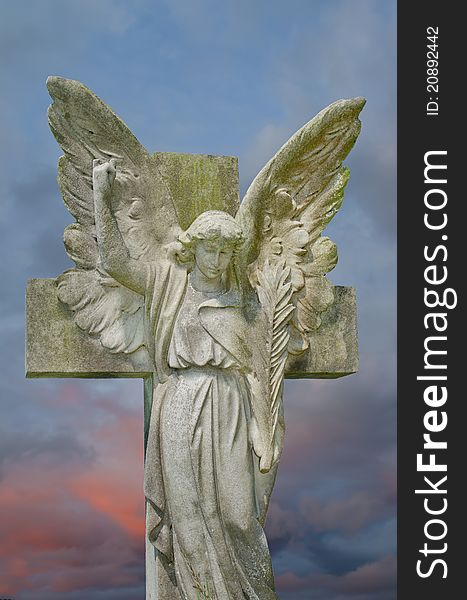 Pre 1900 stone statue gravestone of angel with large wings against a colourful sky. Pre 1900 stone statue gravestone of angel with large wings against a colourful sky.