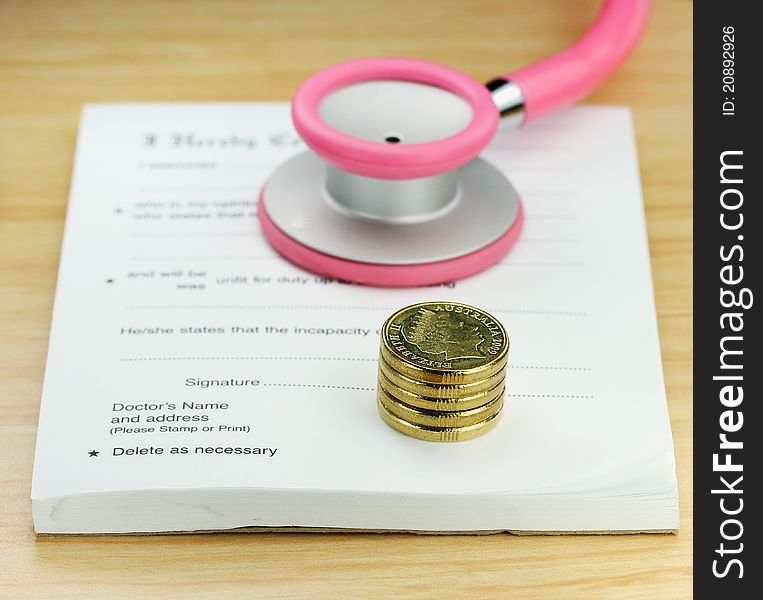A doctor’s desk showing a pink colored stethoscope, stack of gold coins resting on a sick certificate pad, suggesting the price of keeping healthy is rising. A doctor’s desk showing a pink colored stethoscope, stack of gold coins resting on a sick certificate pad, suggesting the price of keeping healthy is rising.