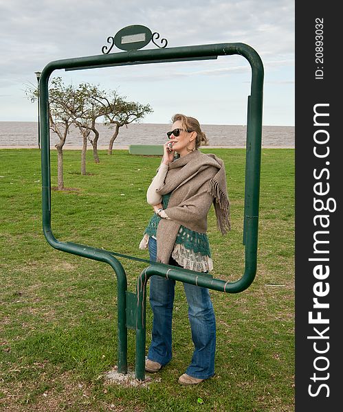 Woman taking on the celular phone, taken framed in a urban park. Woman taking on the celular phone, taken framed in a urban park.