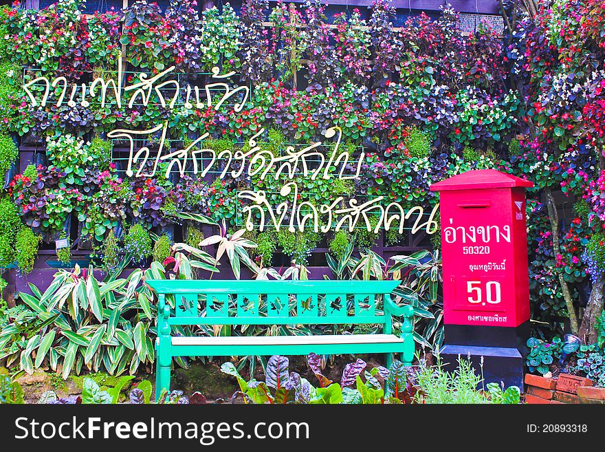 Wooden green chair with red mail box  and  colorful flowers around makes you relax. Wooden green chair with red mail box  and  colorful flowers around makes you relax.