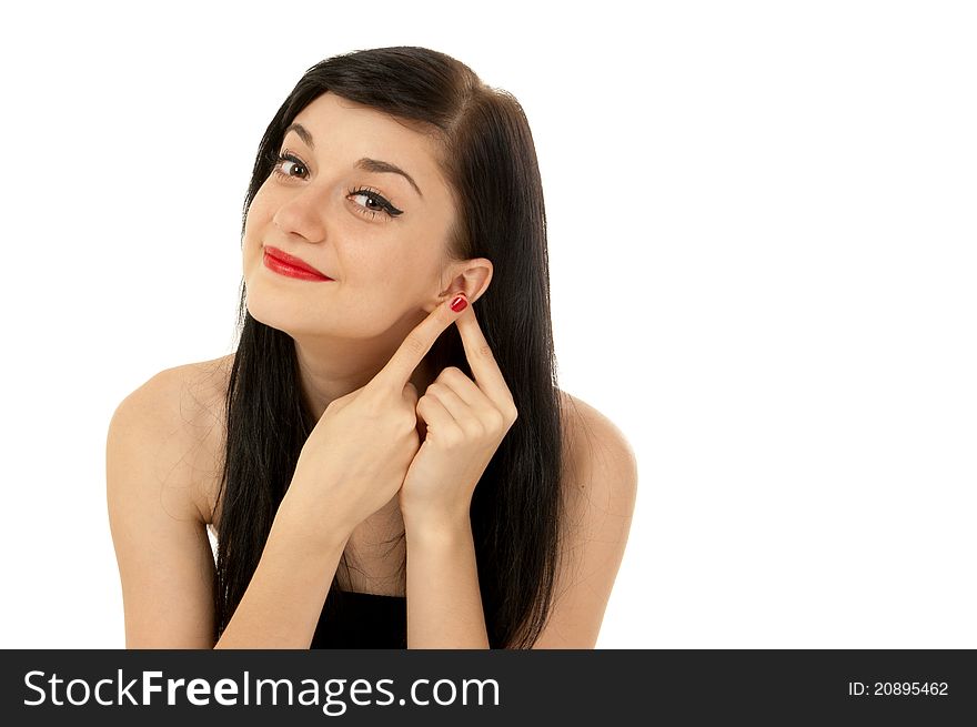 Beautiful brunette girl wearing a black dress putting her fingers to her ear on white background