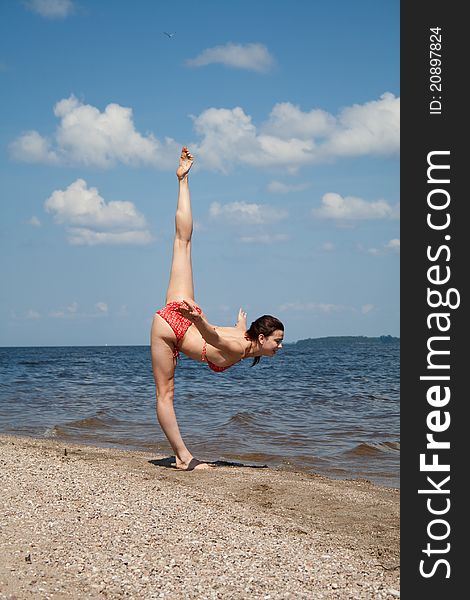 Gymnastics on the beach. beautiful and athletic girl.